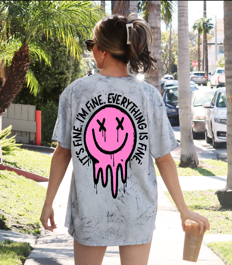 It's Fine Smiley graphic T-shirt by Shop Karma Tees featuring a cheerful yellow smiley face on a casual white tee.
