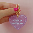 Heart-shaped keychain with "If There's A Woman There's A Way" inscription, by The Bullish Store, featuring a metallic finish.