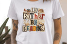 Women's I'd Rather Be Reading graphic tee by Anchored Grace Boutique, featuring a casual design with reading-themed text.