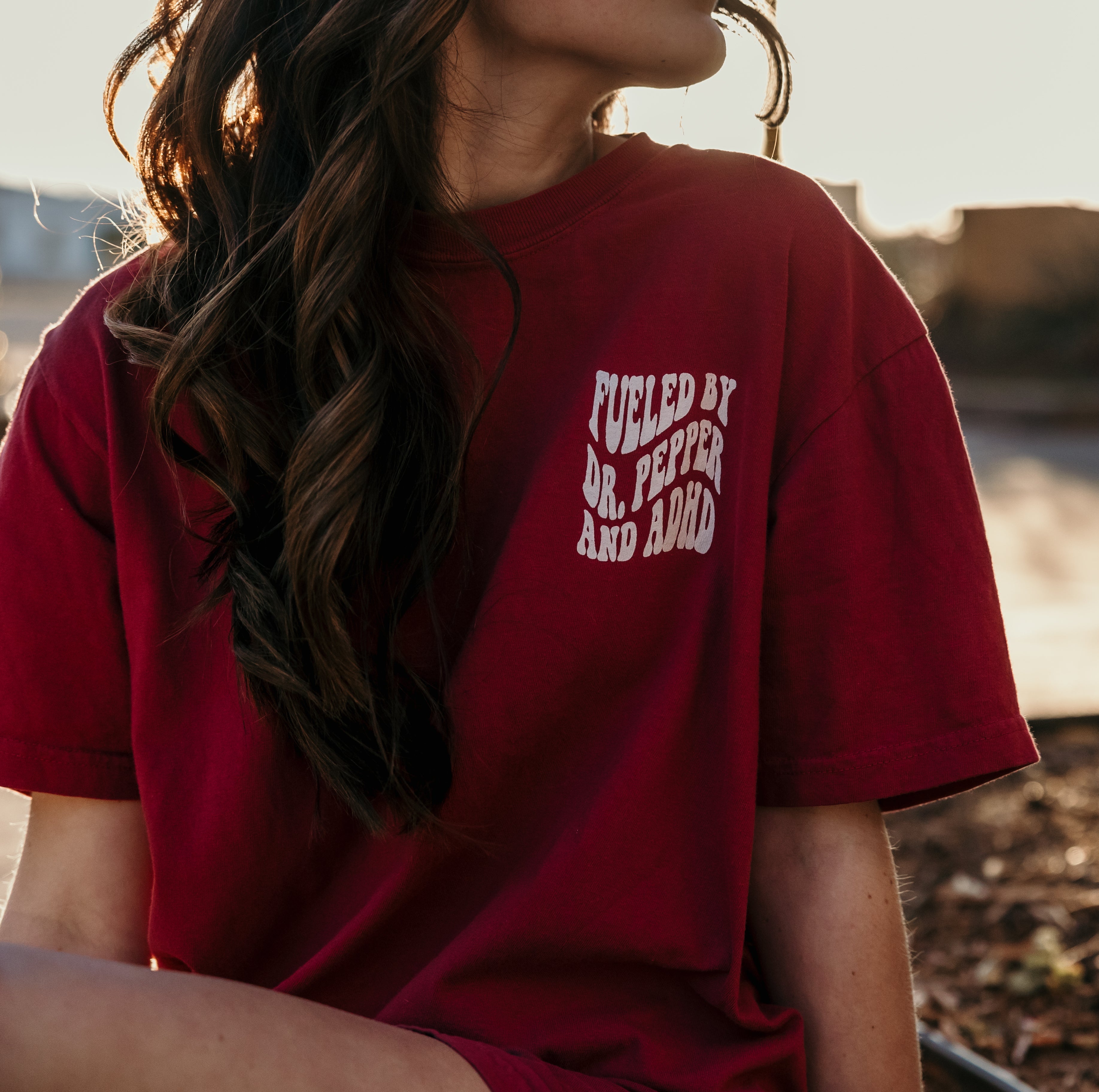 Black graphic T-shirt featuring Dr. Pepper and ADHD designs, from Shop Karma Tees, displayed on a flat lay.