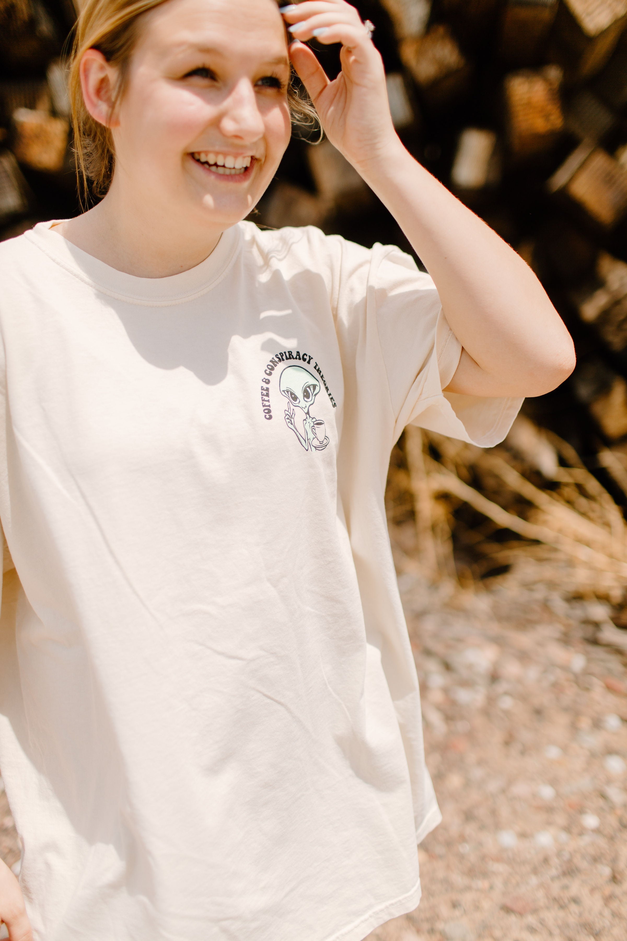 Black graphic t-shirt featuring coffee cups and conspiracy theory illustrations, by Shop Karma Tees.