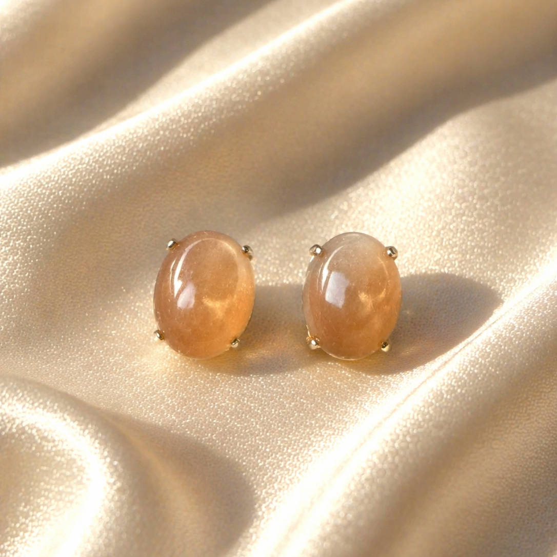 Peach moonstone sterling silver stud earrings with crystal accents, showcasing elegant jewelry design and gemstone detail.