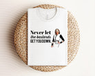 Anchored Grace Boutique graphic tee with bold "Never Let the Bastards Get You Down" design on black cotton shirt.
