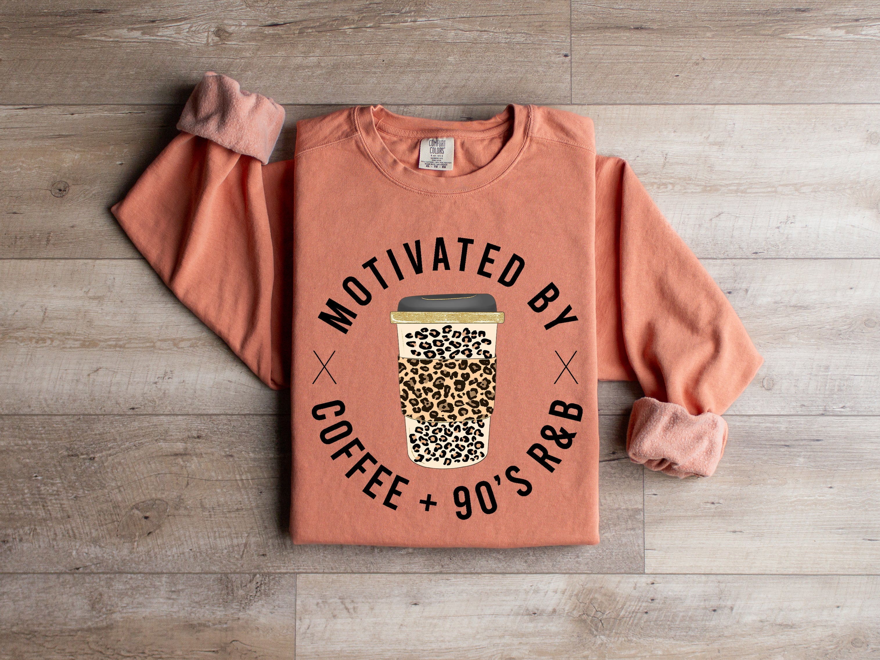 Graphic tee by Anchored Grace Boutique featuring a 90's R&B and coffee-inspired design, displayed on a hanger.