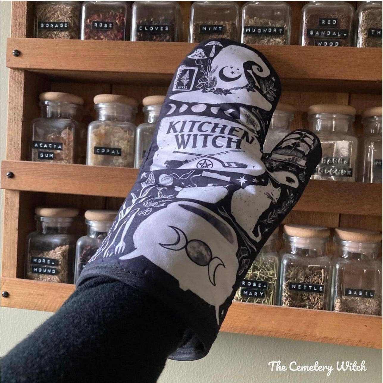 Set of 2 Kitchen Witch oven mitts and pot holders from The Bullish Store, hanging oven gloves with colorful witch design.