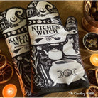 Set of 2 Kitchen Witch oven mitts and pot holders from The Bullish Store, hanging oven gloves with colorful witch design.