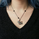 Sourpuss "Good Luck" horseshoe necklace with red rhinestones and black star charms, stylish jewelry from The Bullish Store.