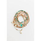 Stack of nine bohemian-inspired pastel beaded and studded bracelets with various textures and colors, perfect for layered jewelry looks.