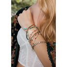 Stacked pastel beaded and studded bohemian jewelry bracelets with nine layers, featuring mixed beads and metallic studs.