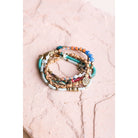 Stack of five teal multi-suede boho bracelets with layered design, featuring various textures and bead accents.