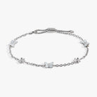 Gold stainless steel anklet featuring butterfly and flower charms by ALEX AND ANI, worn on the ankle with delicate chain links.