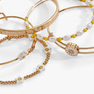 Set of five gold Daisy Flower beaded bangles from ALEX AND ANI, stylish bracelet collection with floral accents.