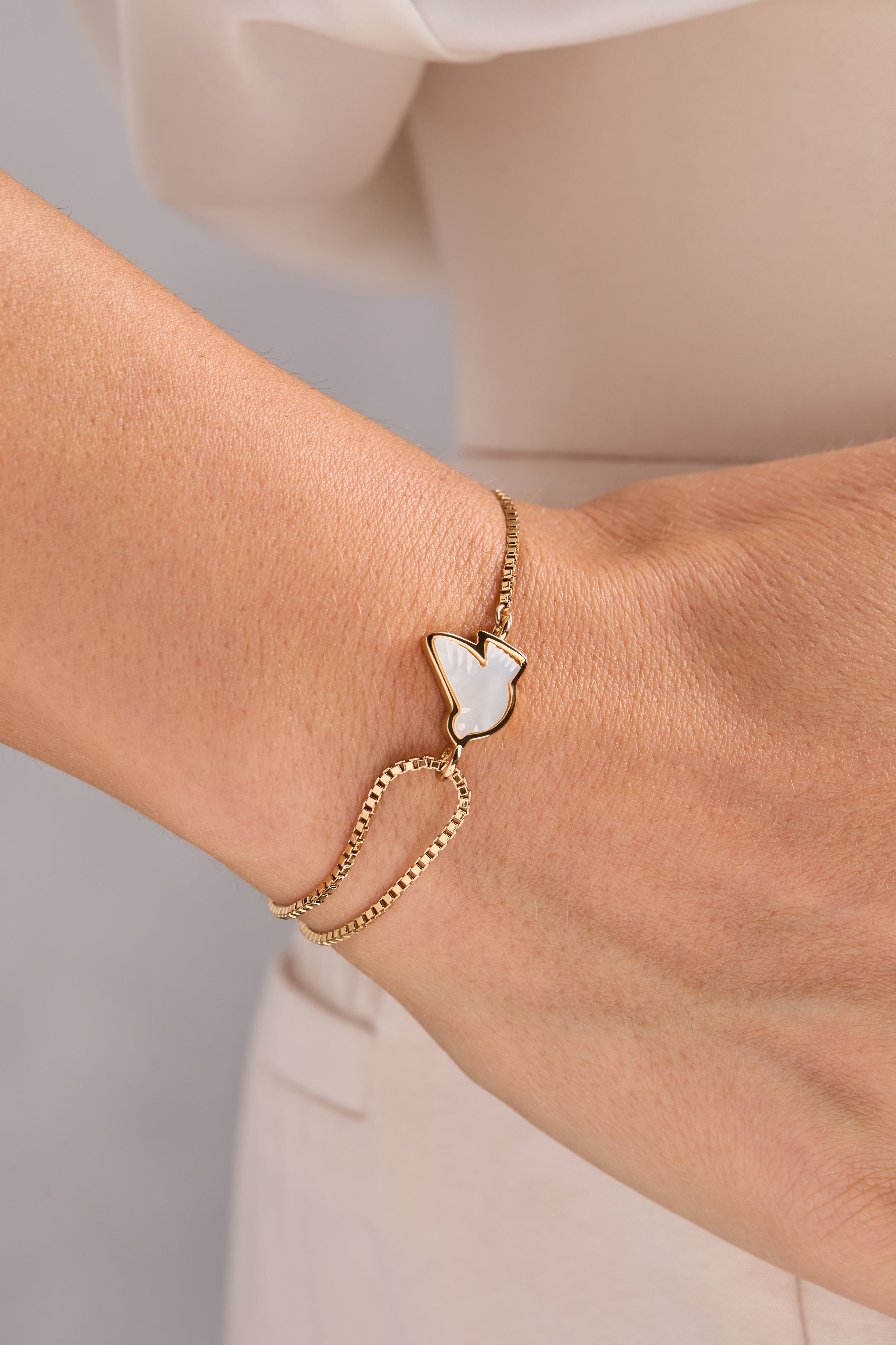 Alex and Ani Dove 'Peace' Mother of Pearl pull chain bracelet featuring gold accents and elegant design.