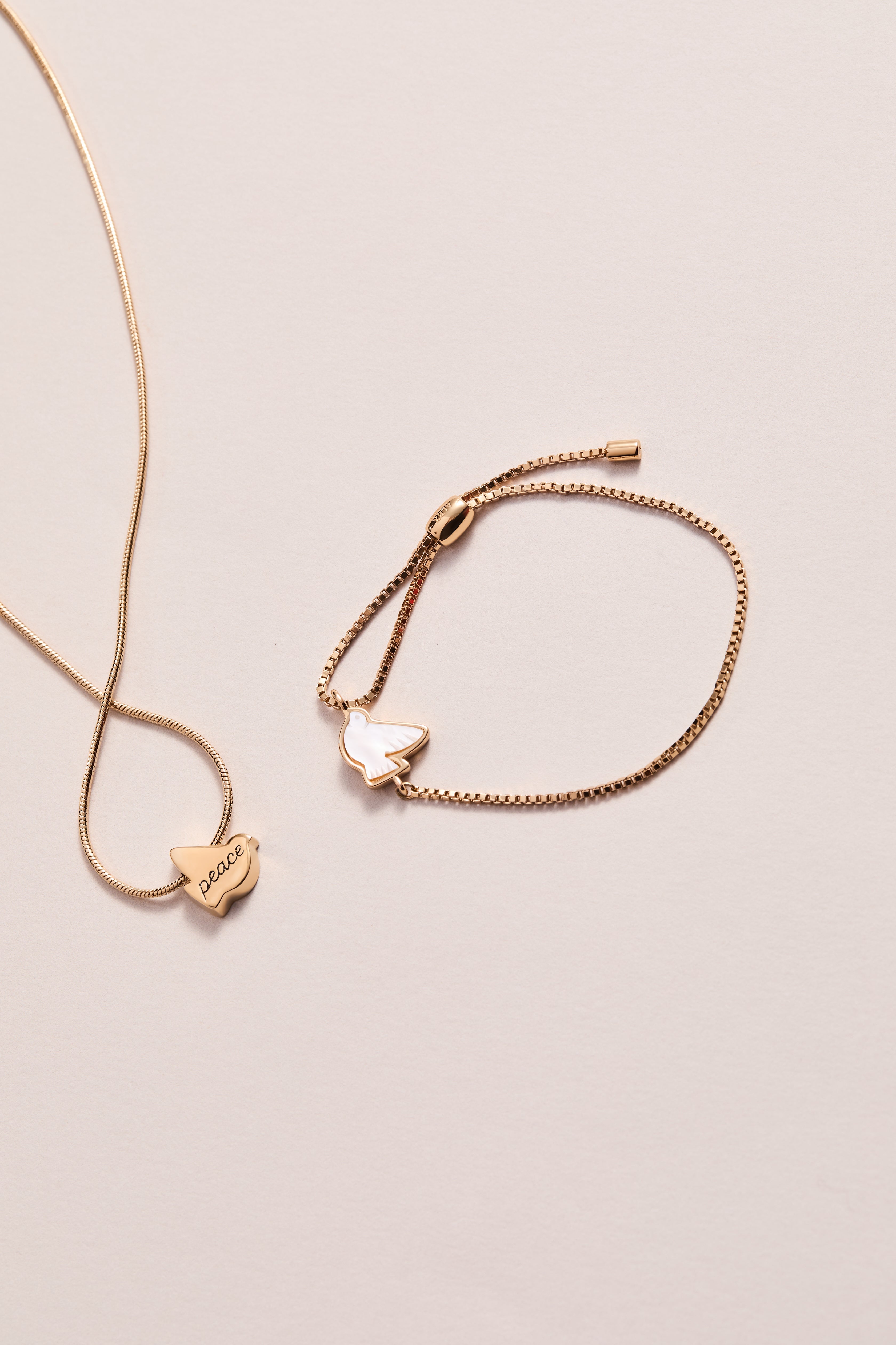 ALEX AND ANI Dove 'Peace' gold mother of pearl pull chain bracelet featuring a dove charm and elegant design.