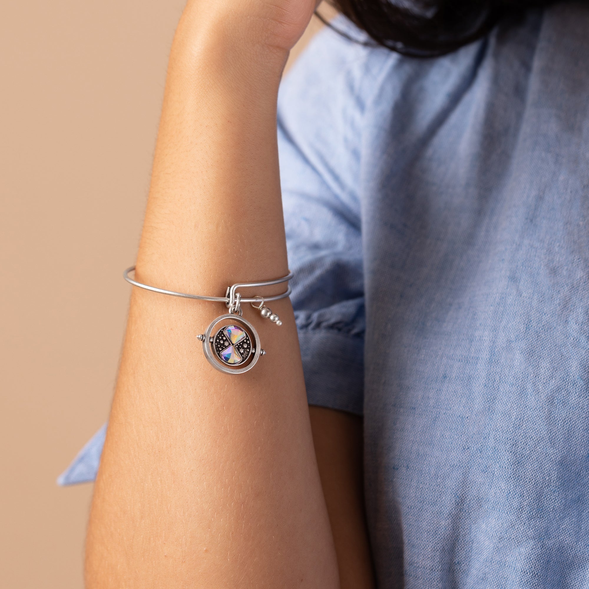 ALEX AND ANI Harry Potter™ Time Turner Spinner Charm Bangle bracelet with silver finish and detailed time turner charm.