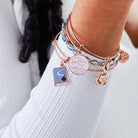 Set of three shiny rose gold Harry Potter Hermione 'Leviosa' bangles by ALEX AND ANI, featuring magical design elements.