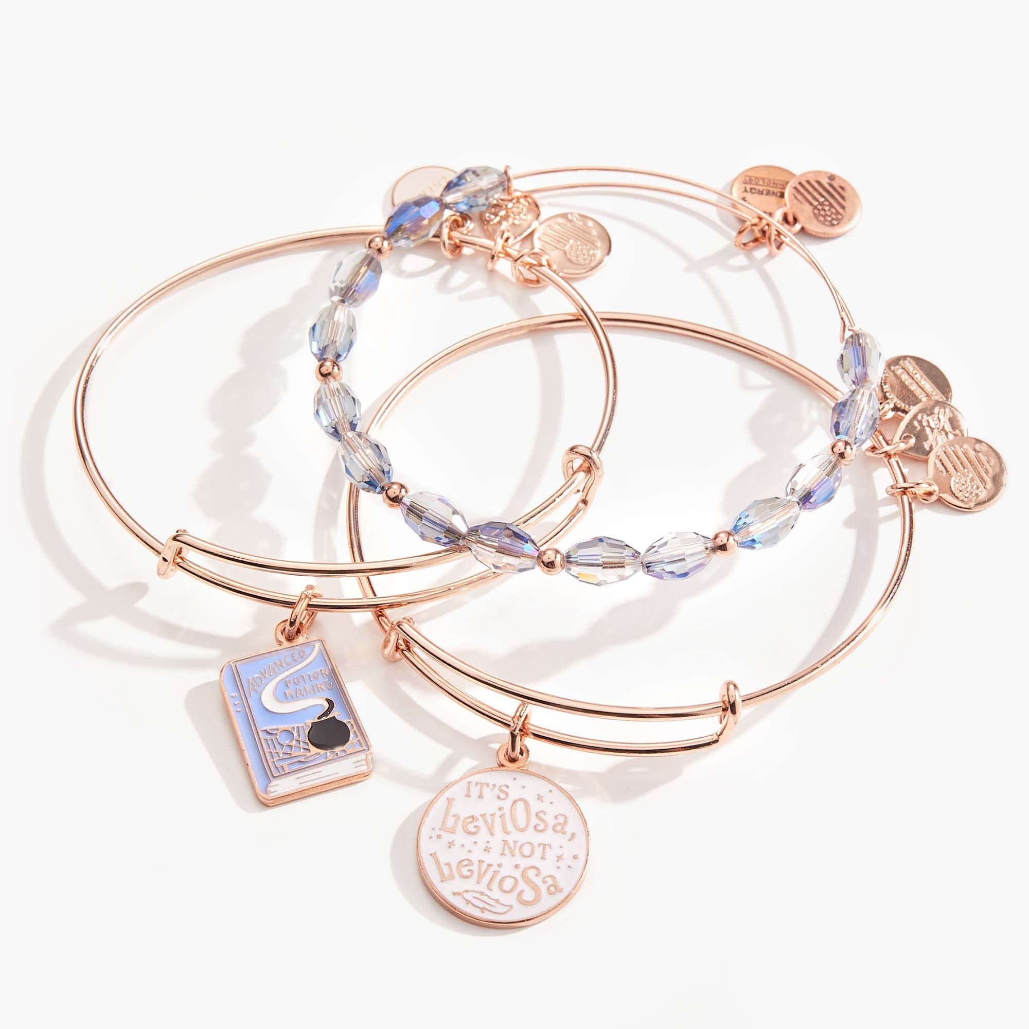 Set of three shiny rose gold Harry Potter Hermione 'Leviosa' bangle bracelets by ALEX AND ANI, featuring magical design details.