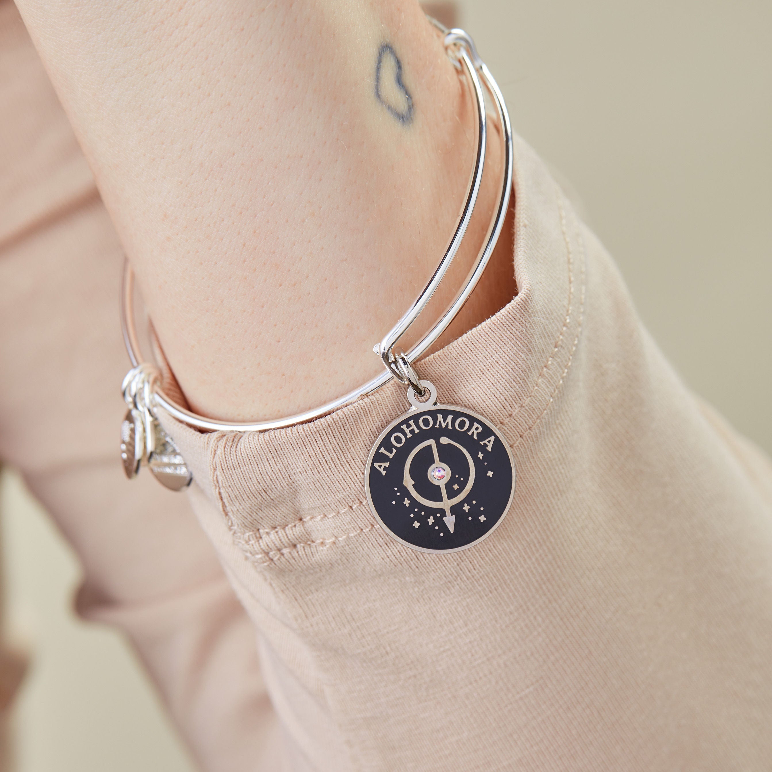 Shiny silver Harry Potter Alohomora charm bangle bracelet by ALEX AND ANI with engraved magical lock symbol.