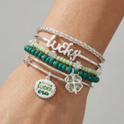 Set of five silver ALEX AND ANI Lucky Four-Leaf Clover bangles, featuring delicate charms and sleek bracelet designs.