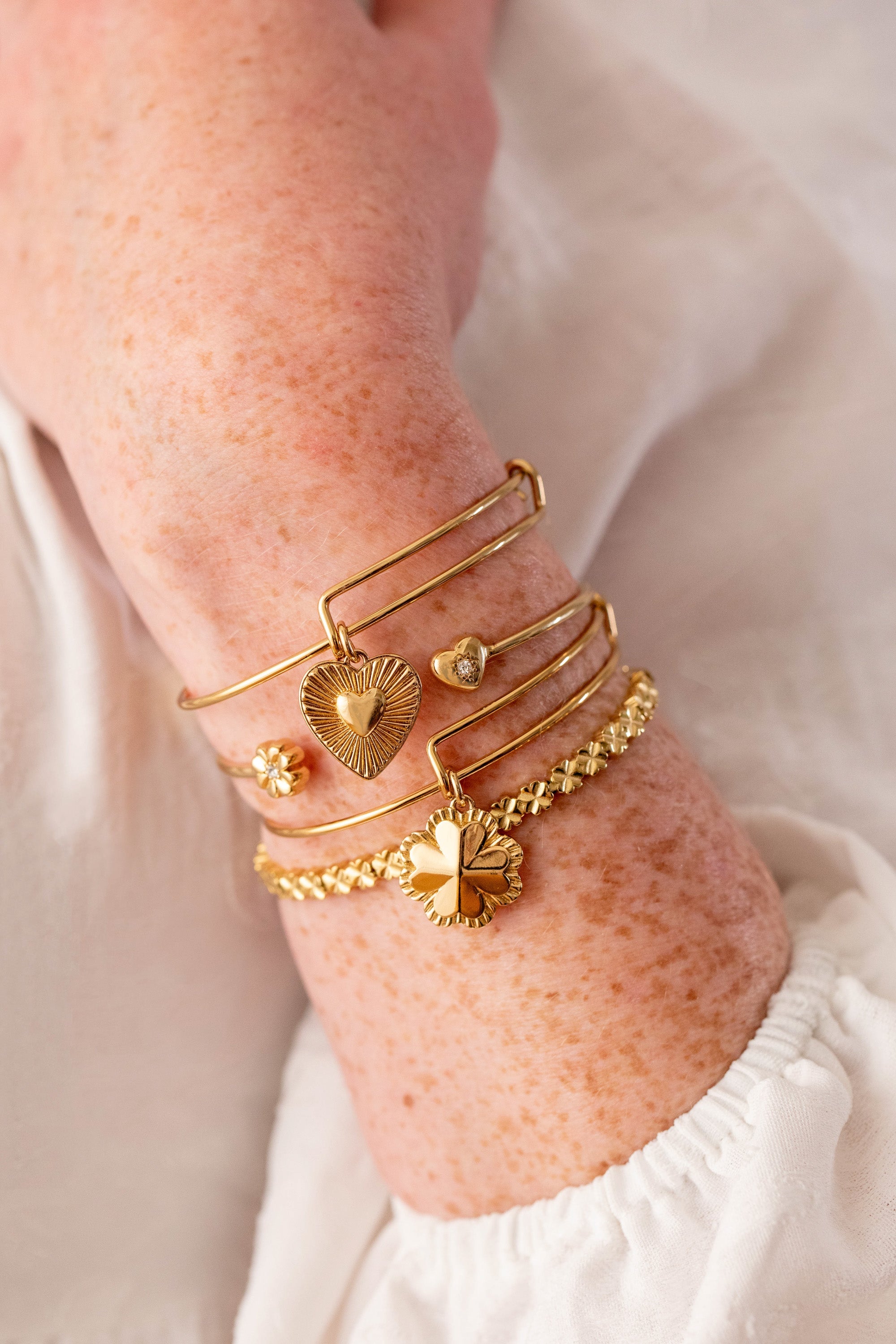 Gold stainless steel tennis bracelet by ALEX AND ANI featuring a lucky clover charm and elegant design.