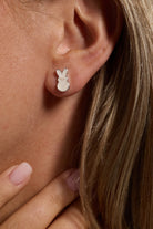 A pair of PEEPS® White Pearlized Bunny Stud Earrings by ALEX AND ANI featuring gold-tone bunny designs with pearlized finish.