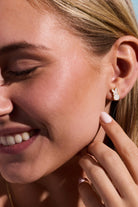 A pair of ALEX AND ANI PEEPS White Pearlized Bunny Stud Earrings with gold accents, featuring adorable bunny shapes on a white pearl finish.