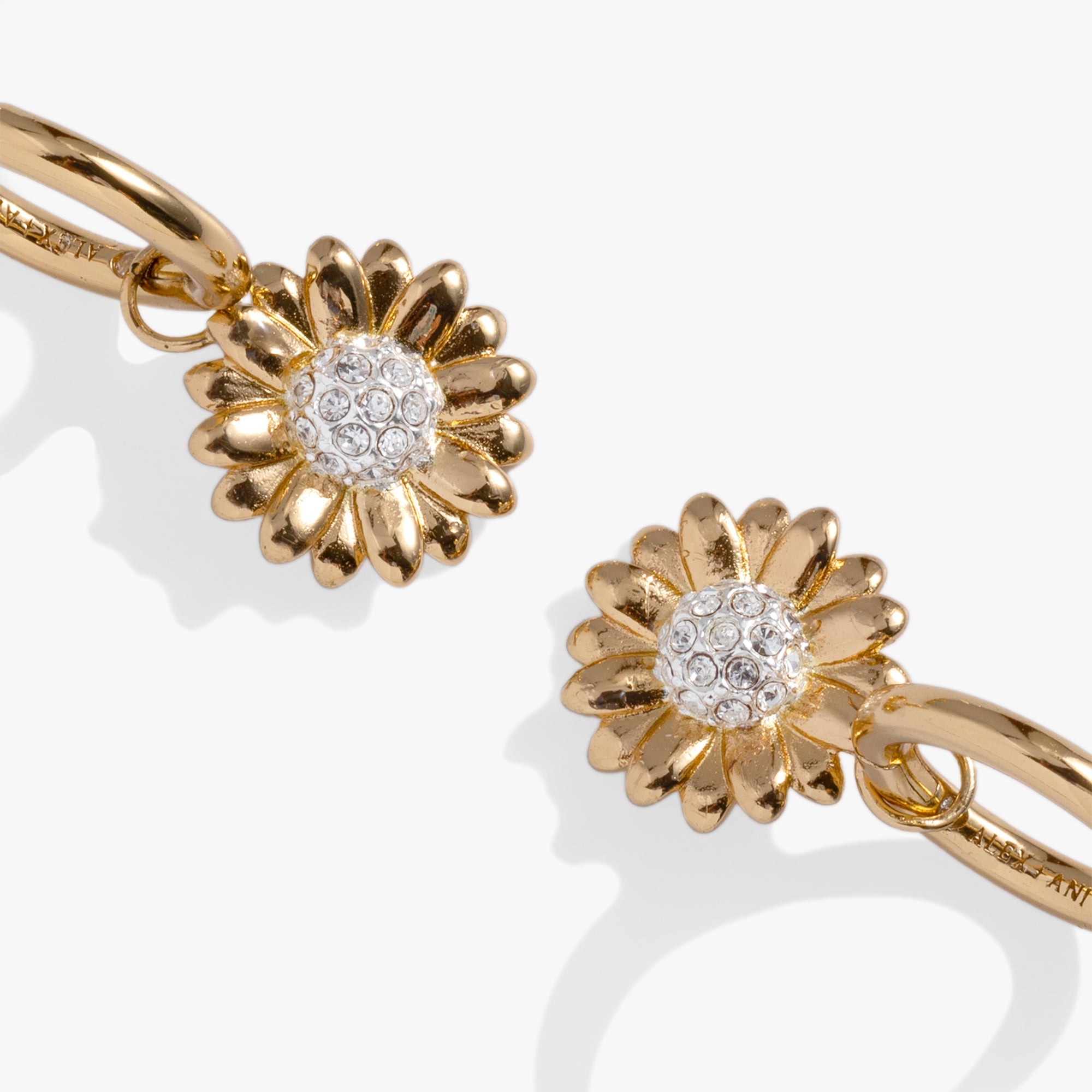 Two-tone sunflower huggie hoop earrings by ALEX AND ANI featuring detailed sunflower design and small hoop style.