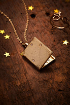 Gold Harry Potter Mischief Managed locket necklace by ALEX AND ANI featuring engraved Hogwarts crest and mystical design.