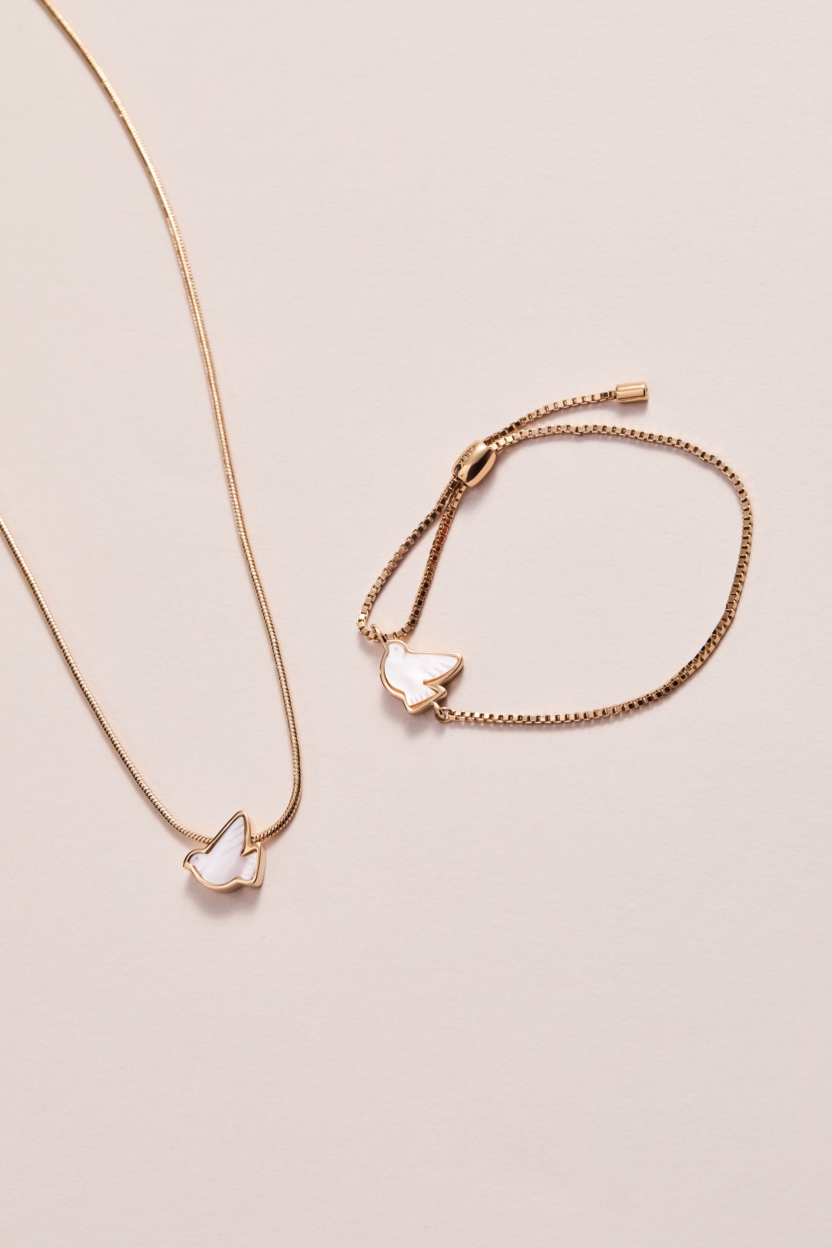 Gold pearlized Dove 'Peace' slider necklace by ALEX AND ANI, featuring a dove pendant on a delicate chain.