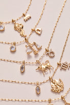 Gold Aquarius Zodiac Charm Cluster Necklace by ALEX AND ANI featuring stainless steel chain and celestial zodiac charms.