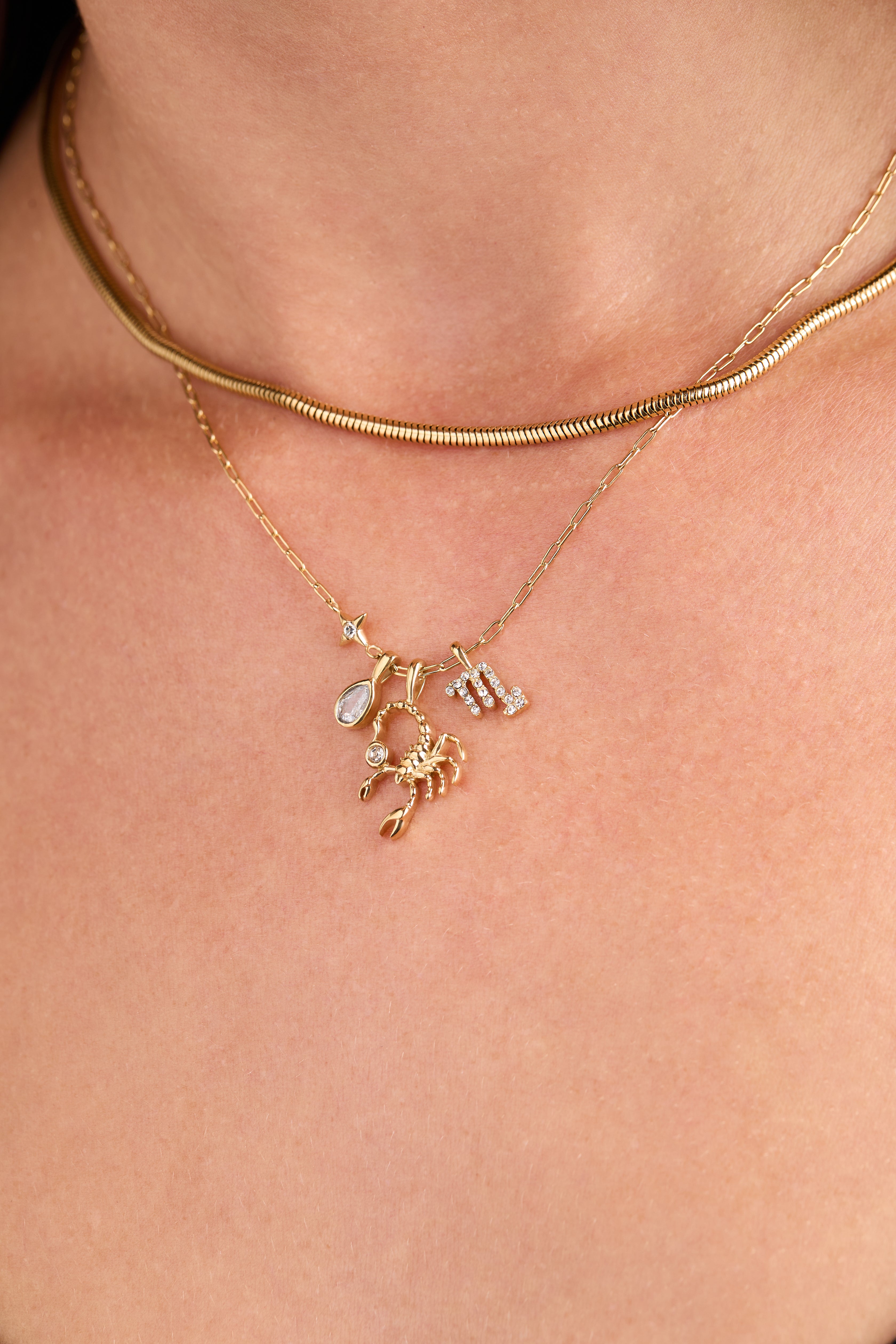 Gold stainless steel Scorpio zodiac charm cluster necklace by ALEX AND ANI, featuring a detailed Scorpio pendant and layered chain design.