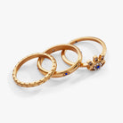 Set of three gold stainless steel evil eye stacking rings by ALEX AND ANI, featuring intricate eye designs for stylish layered look.