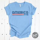 America 1776 retro-inspired short sleeve graphic tee from The Graphic Tee, featuring patriotic design and classic style.