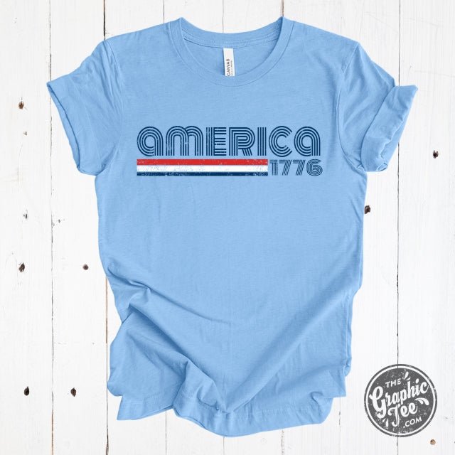 America 1776 retro-inspired short sleeve graphic tee from The Graphic Tee, featuring patriotic design and classic style.