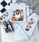 Black football ghost graphic tee from Anchored Grace Boutique, featuring a playful football and ghost design on a casual graphic tee.