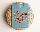 White fall football heart graphic tee by Anchored Grace Boutique featuring a seasonal football and heart design.