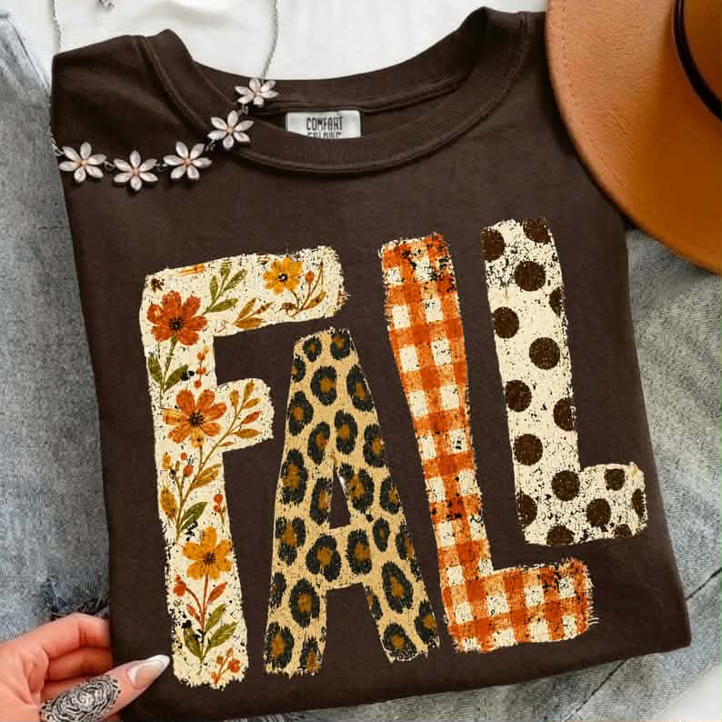White fall patterned graphic tee from Anchored Grace Boutique featuring autumn-inspired designs and casual style.