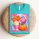 White football and fall graphic tee from Anchored Grace Boutique, featuring seasonal autumn and sports-themed design.