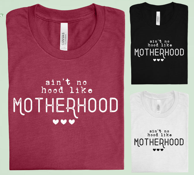 Black graphic tee featuring "Ain't No Hood Like Motherhood" text from Anchored Grace Boutique, casual wear for moms.