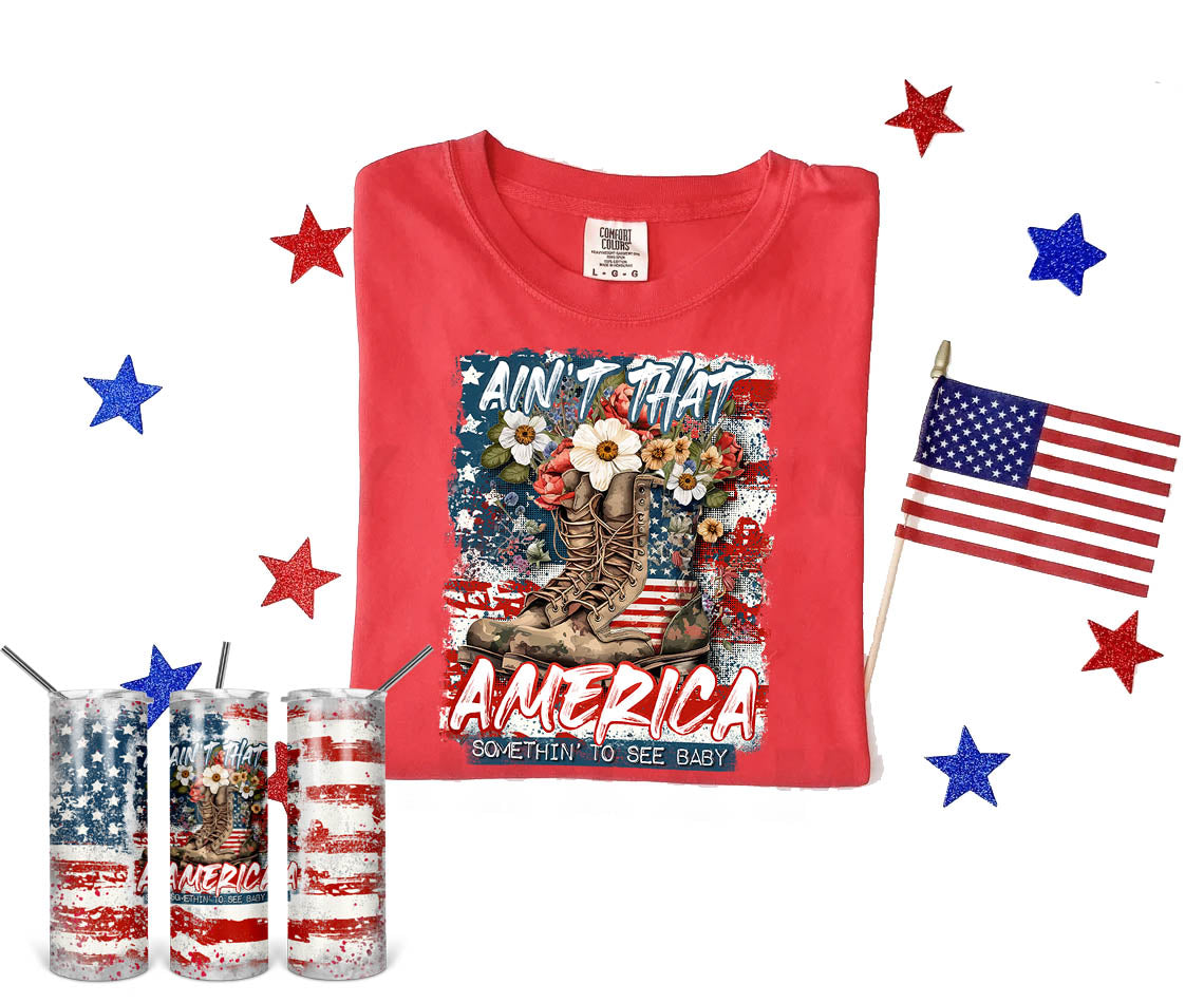 A graphic tee from Anchored Grace Boutique featuring "Ain't That America" slogan with patriotic design and casual fit.