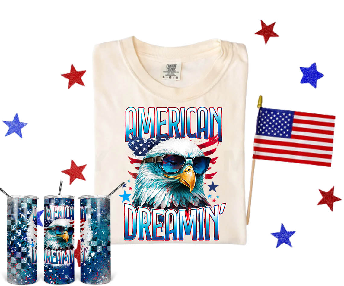 American Dreamin graphic tee by Anchored Grace Boutique featuring bold text and vibrant design on a casual cotton shirt.