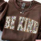 Be Kind graphic tee by Anchored Grace Boutique featuring a colorful, inspirational design on a casual cotton t-shirt.