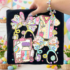 Easter Nurse graphic tee by Anchored Grace Boutique featuring a festive nurse illustration on a casual cotton t-shirt.