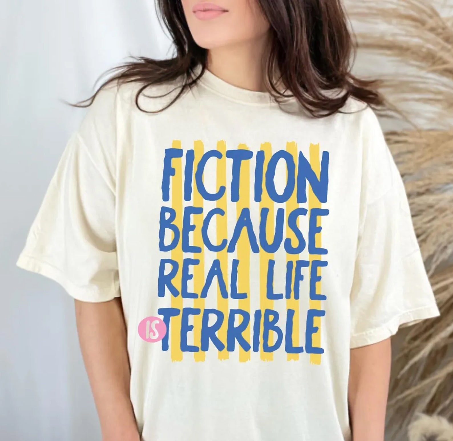 Black graphic tee from Anchored Grace Boutique with "Because Real Life is Terrible" text, casual fit, and soft cotton fabric.