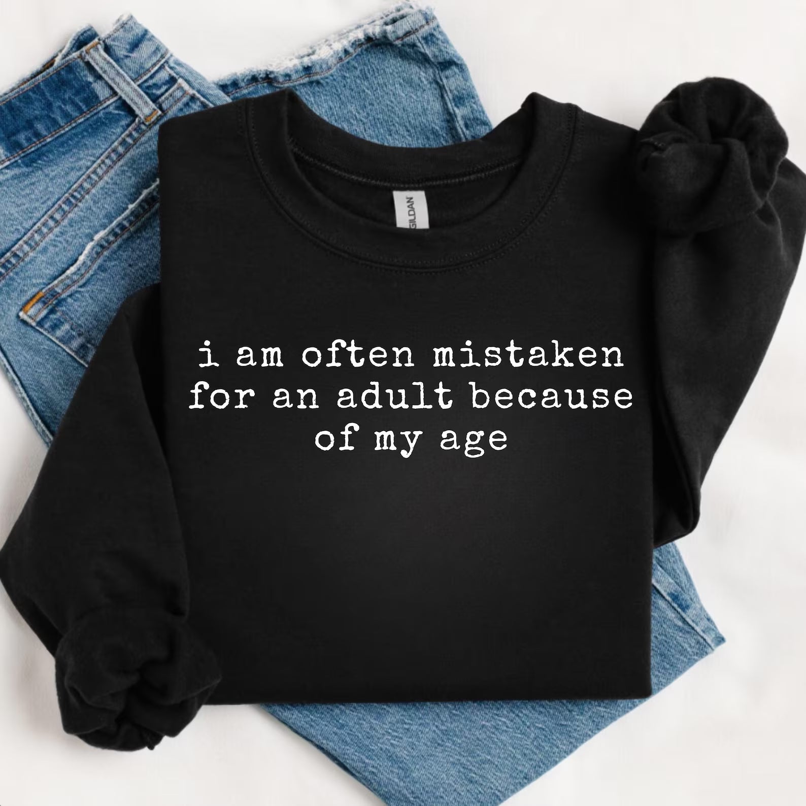 Black graphic tee from Anchored Grace Boutique with humorous "I am Often Mistaken for an Adult" design, casual fit and soft fabric.