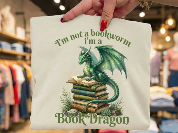 Colorful "I'm a Book Dragon" graphic tee by Anchored Grace Boutique featuring a whimsical dragon and book illustration.