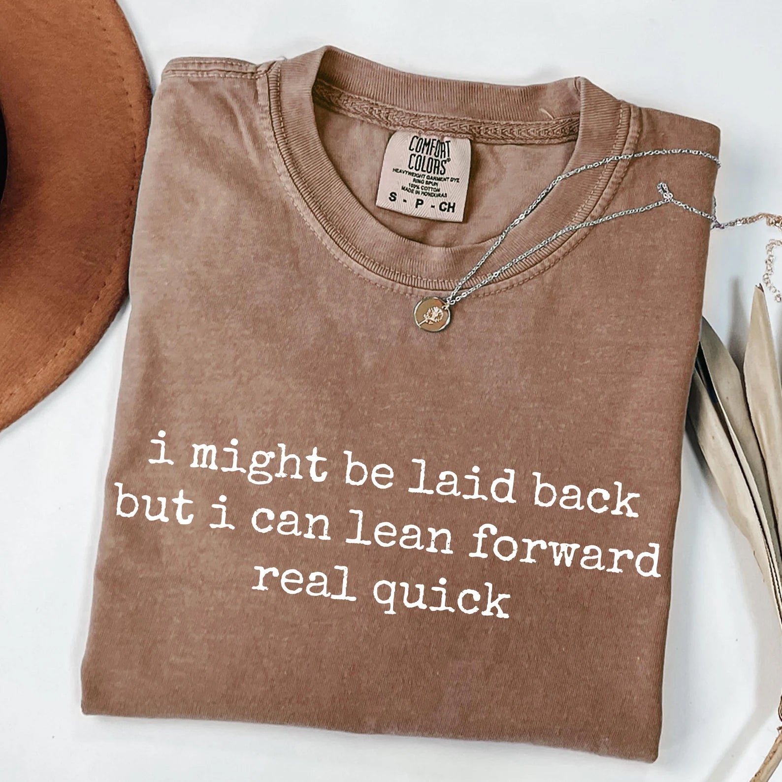 Black graphic tee from Anchored Grace Boutique with "I Might Be Laid Back" slogan and casual fit.