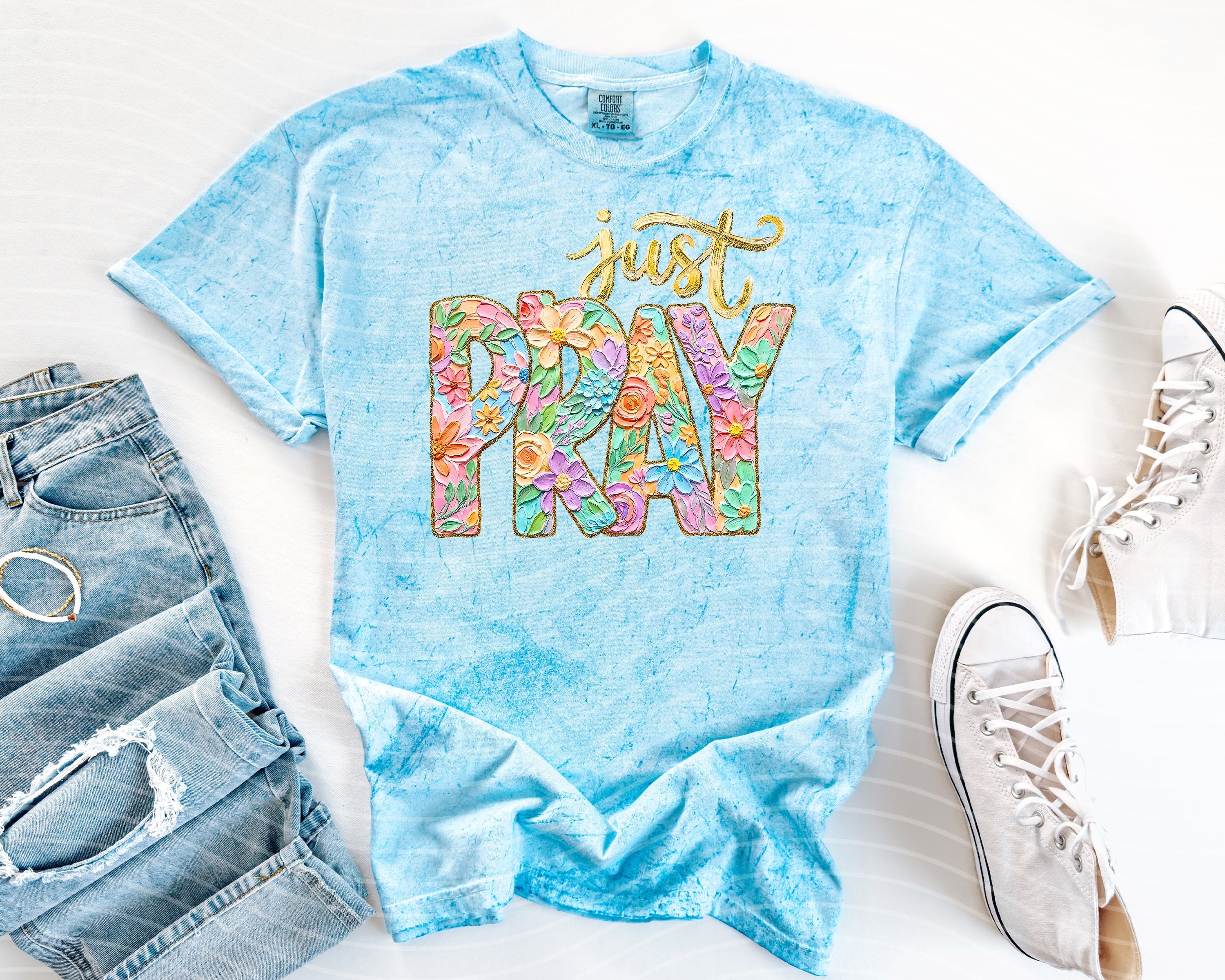 Black graphic tee from Anchored Grace Boutique with "Just Pray" slogan and prayer-themed design on the front.