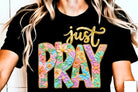 Black Just Pray graphic tee by Anchored Grace Boutique featuring a spiritual design and bold lettering on soft cotton fabric.