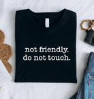 Black graphic tee by Anchored Grace Boutique with "Not Friendly Do Not Touch" design, casual fit, and bold statement print.